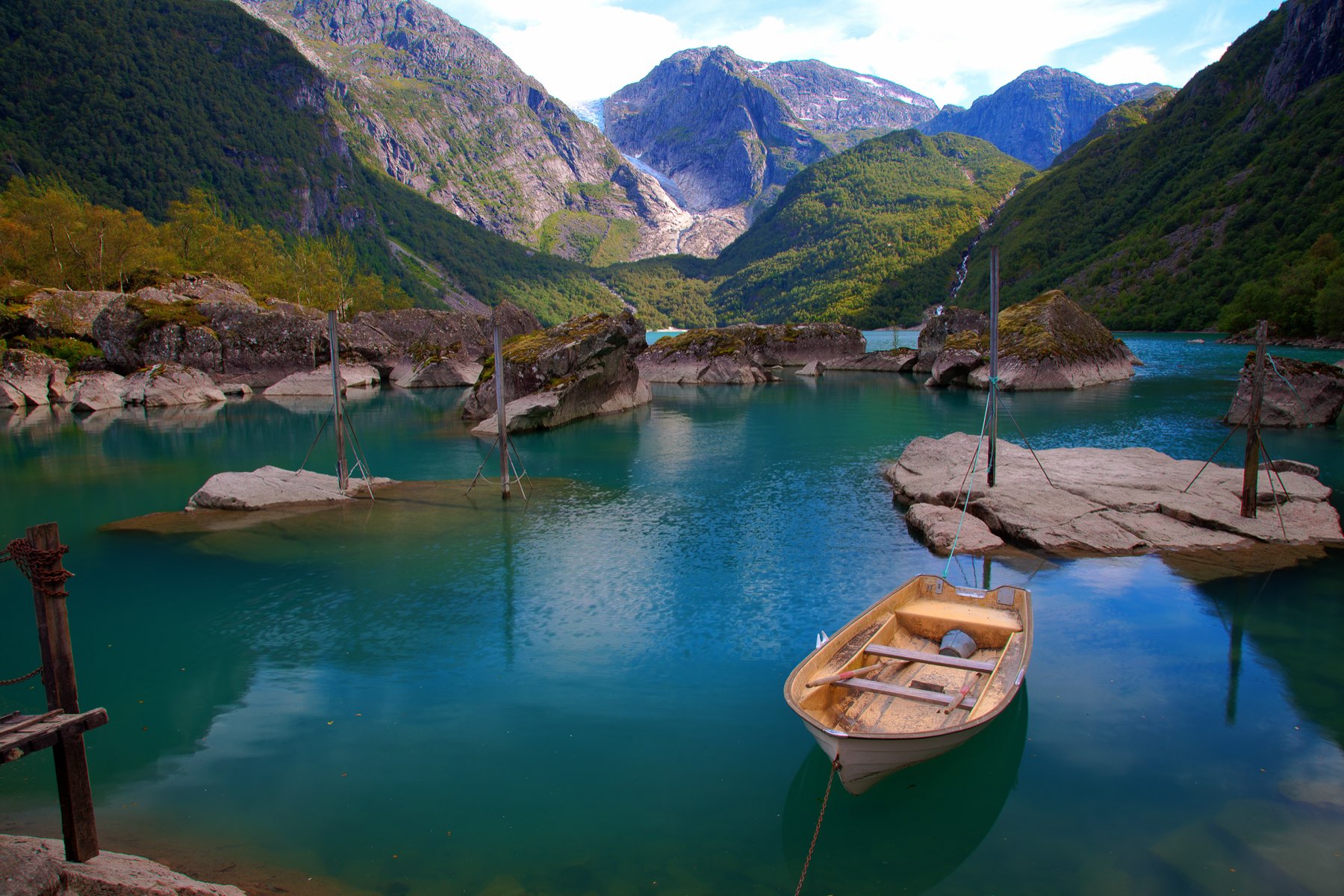 A turquoise lake beneath steep forested mountains at Bondhusvatnet, Norway